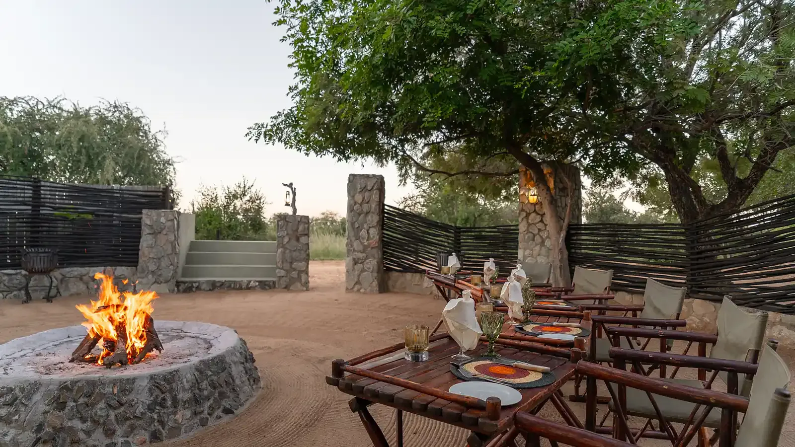 A Nzumba boma dinner setting under firelight