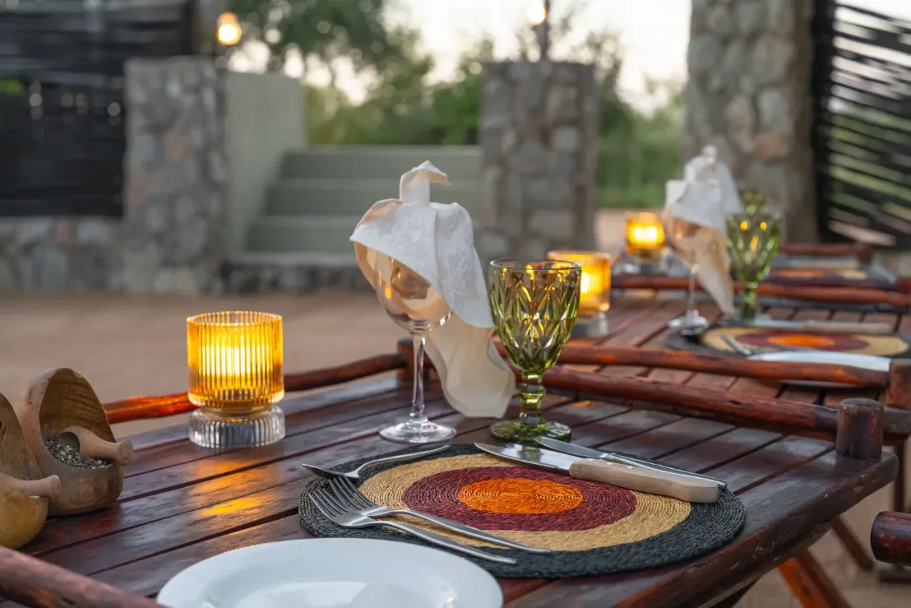 Boma table laid for evening service with lanterns flickering
