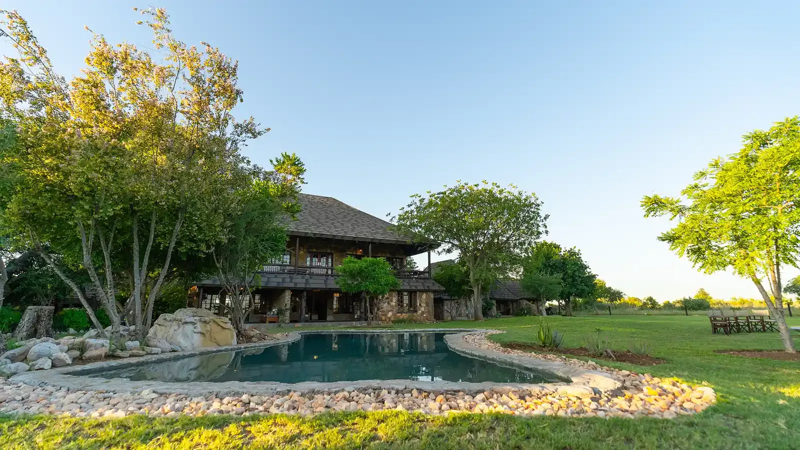 Nzumba Lodge's main gathering area — warm timbered ceiling and lounge seating