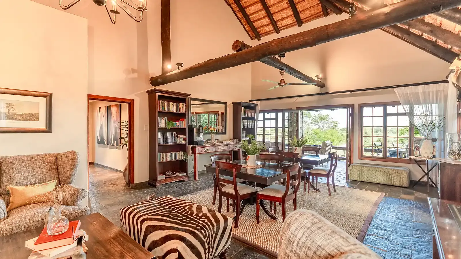 The Nzumba Lodge bar — bottles and glassware against rough-cut timber