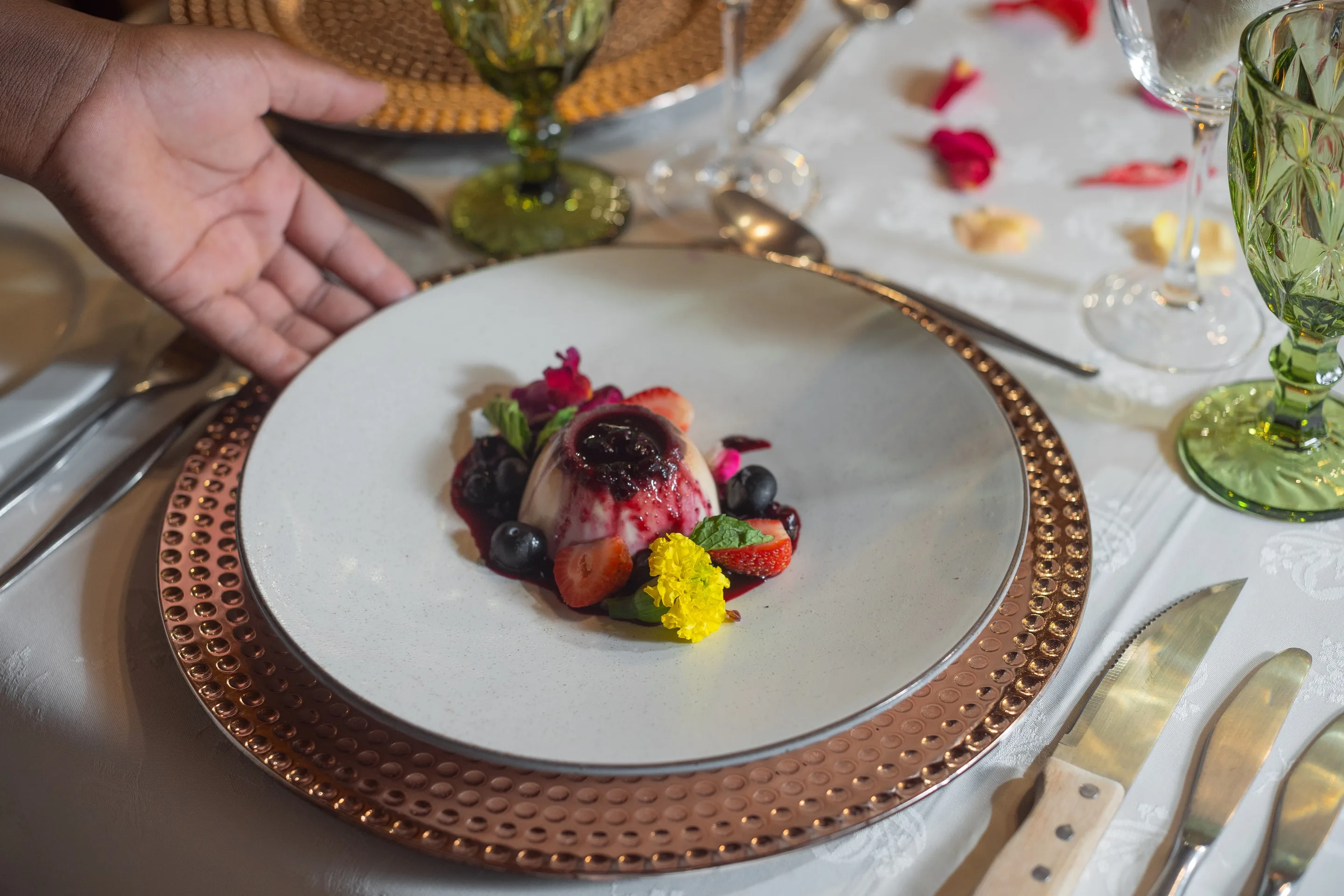 A plated Nzumba dessert with sorbet, fresh fruit and floral garnish