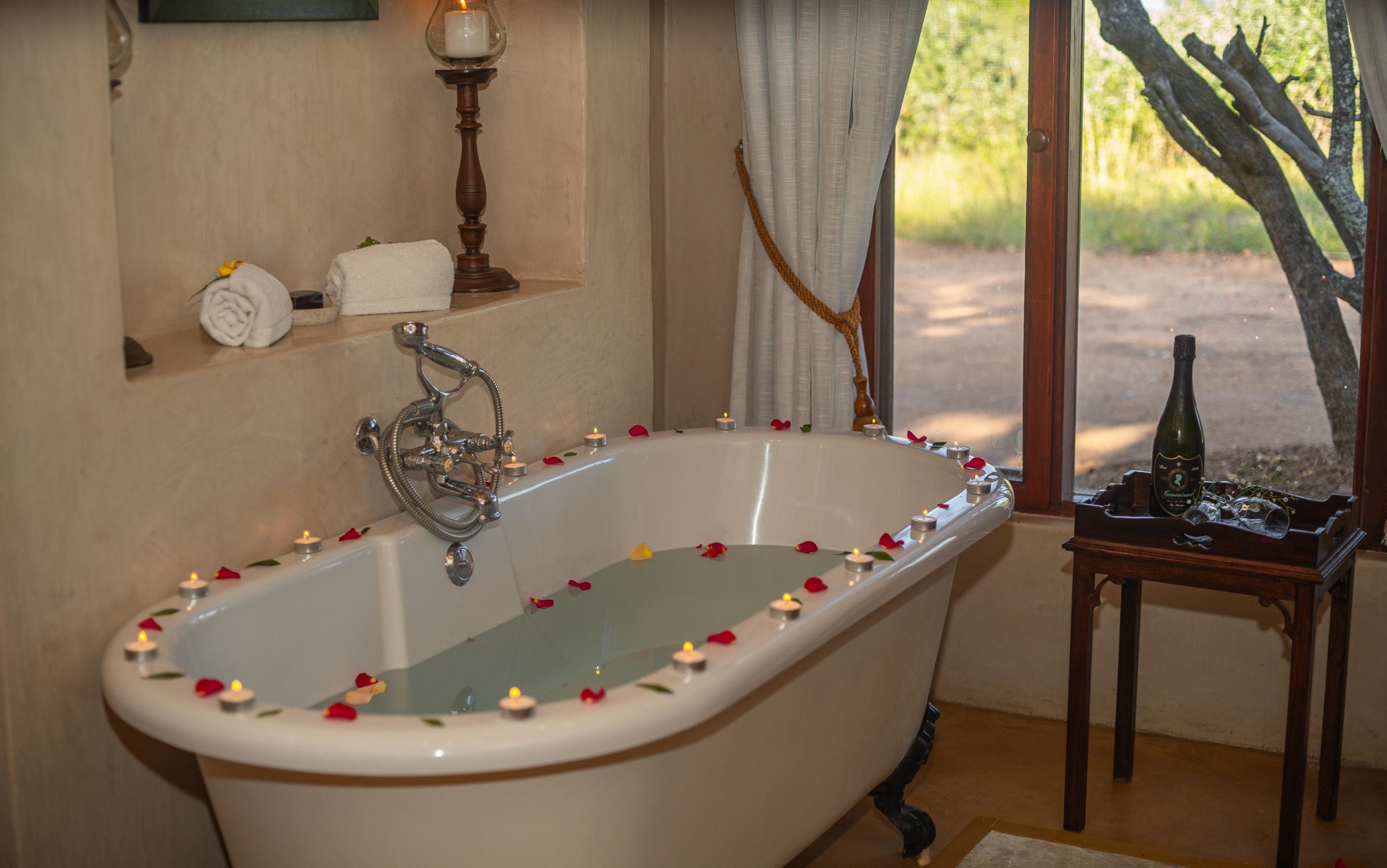A romantic honeymoon suite turn-down at Nzumba — towel art and rose petals