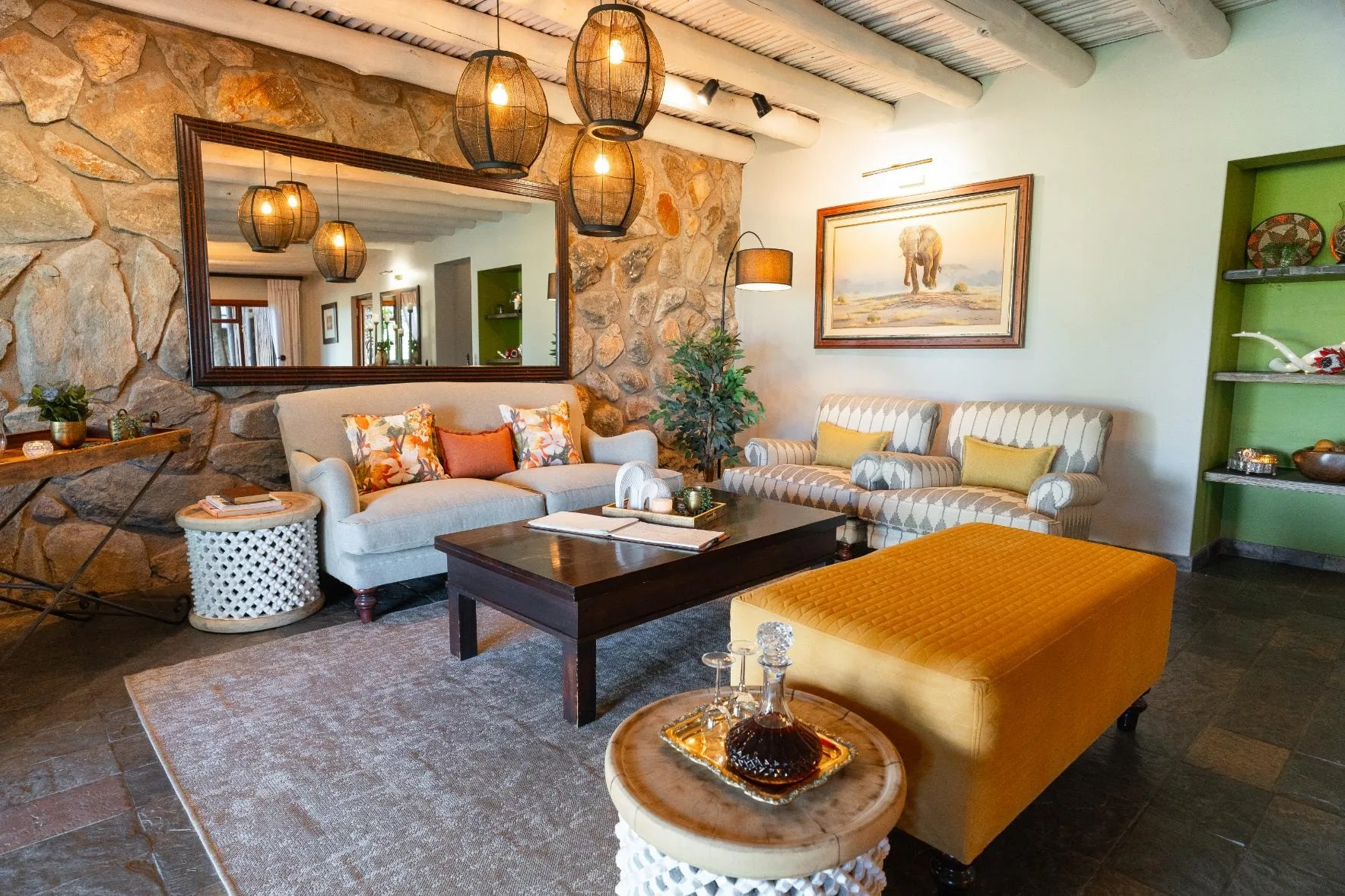 Lounge at Nzumba Lodge with stone wall, leather chairs and elephant artwork