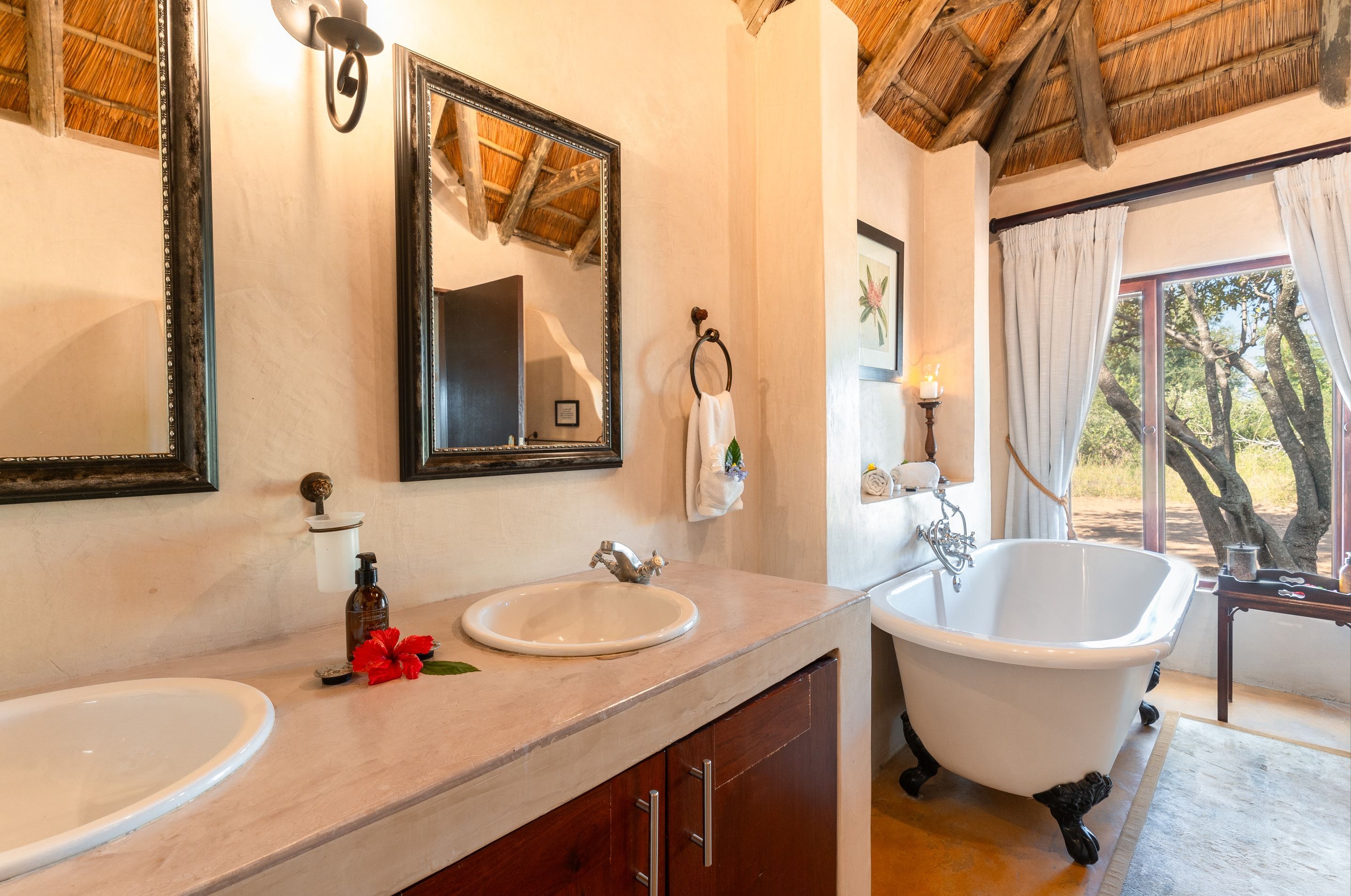 A free-standing bathtub at Nzumba Lodge with a bushveld view through the window
